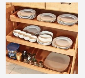 a wooden drawer filled with plates , bowls , salt and pepper shakers .